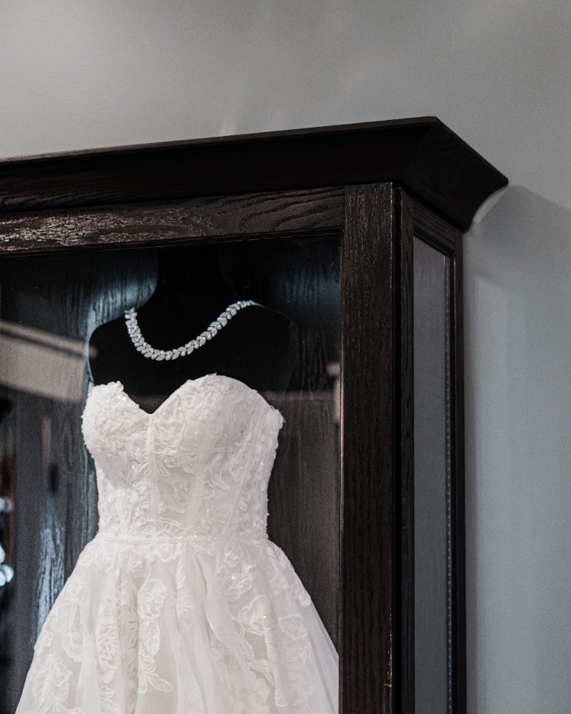 A lace bodice and necklace displayed inside a black Mrs. Case