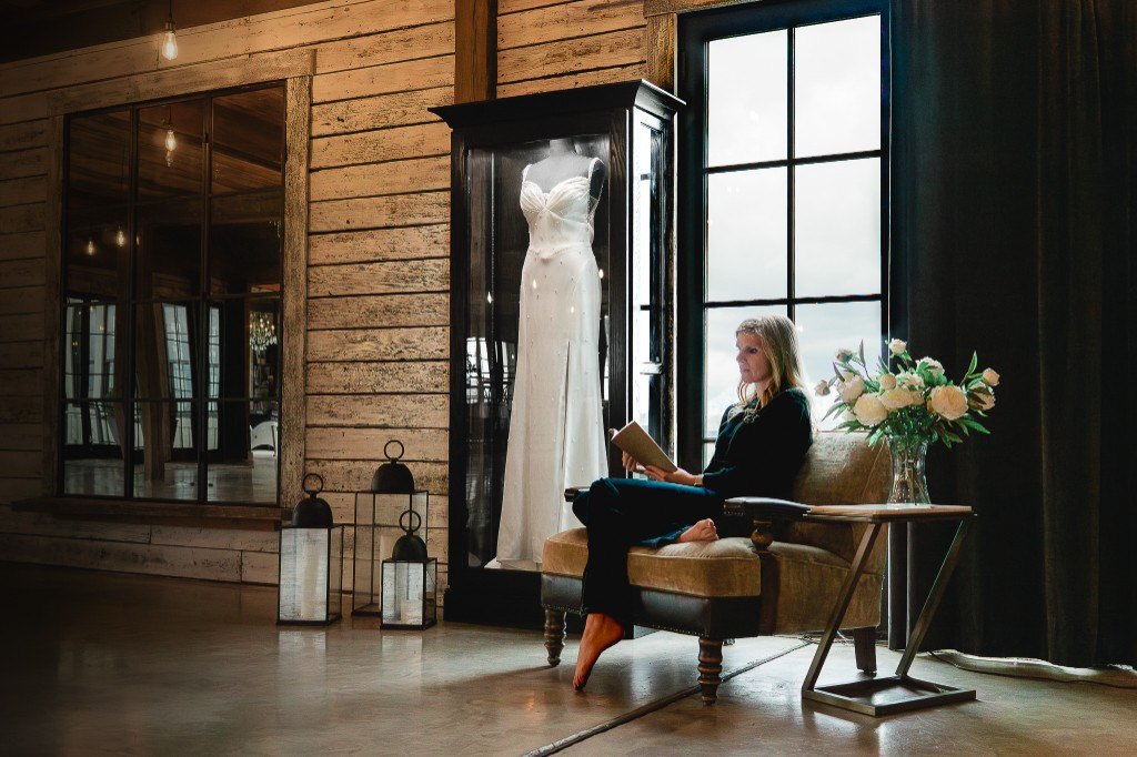 A woman reading in a chair beside a freestanding Mrs. Case